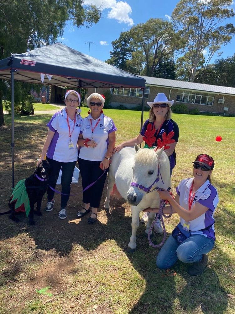 Volunteers with a pony and dogs at an outdoor event